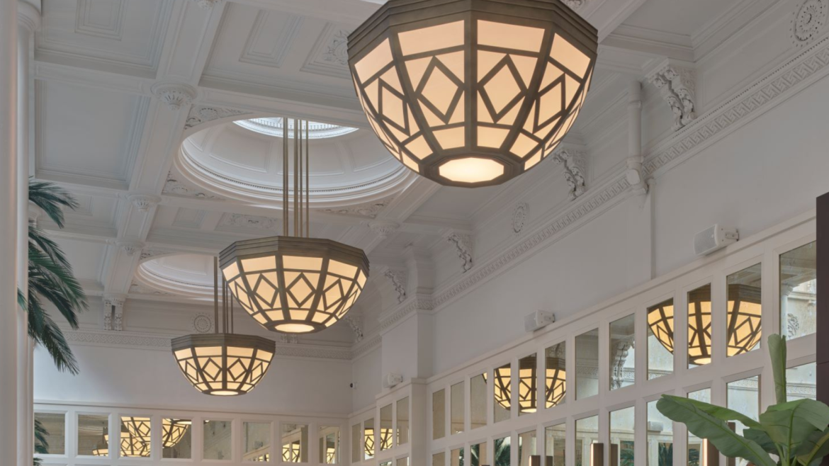 Tall panelled ceiling in white with structural pendants and mirrored walls