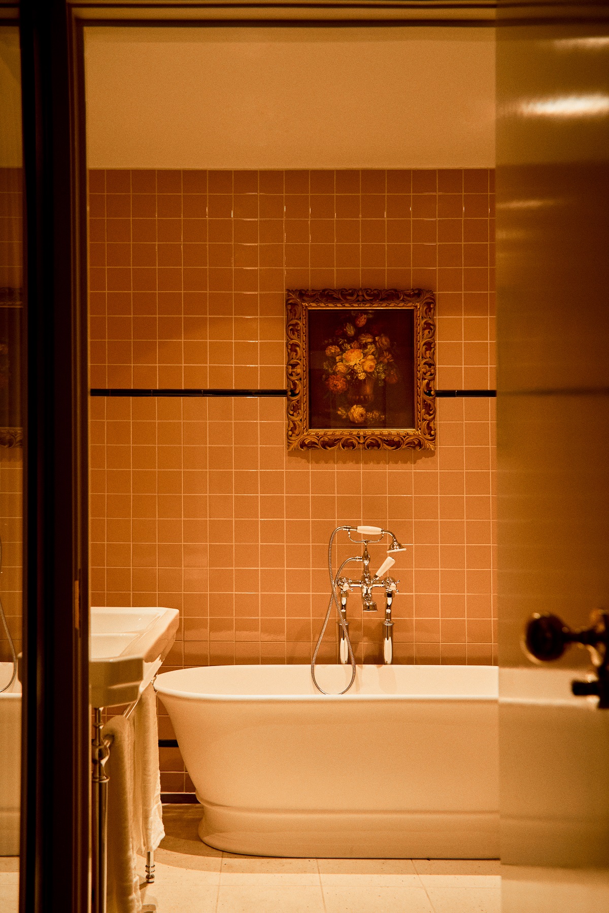 freestanding bath with traditional fittings and single oil painting above in Grand Hotel Bellevue guestroom