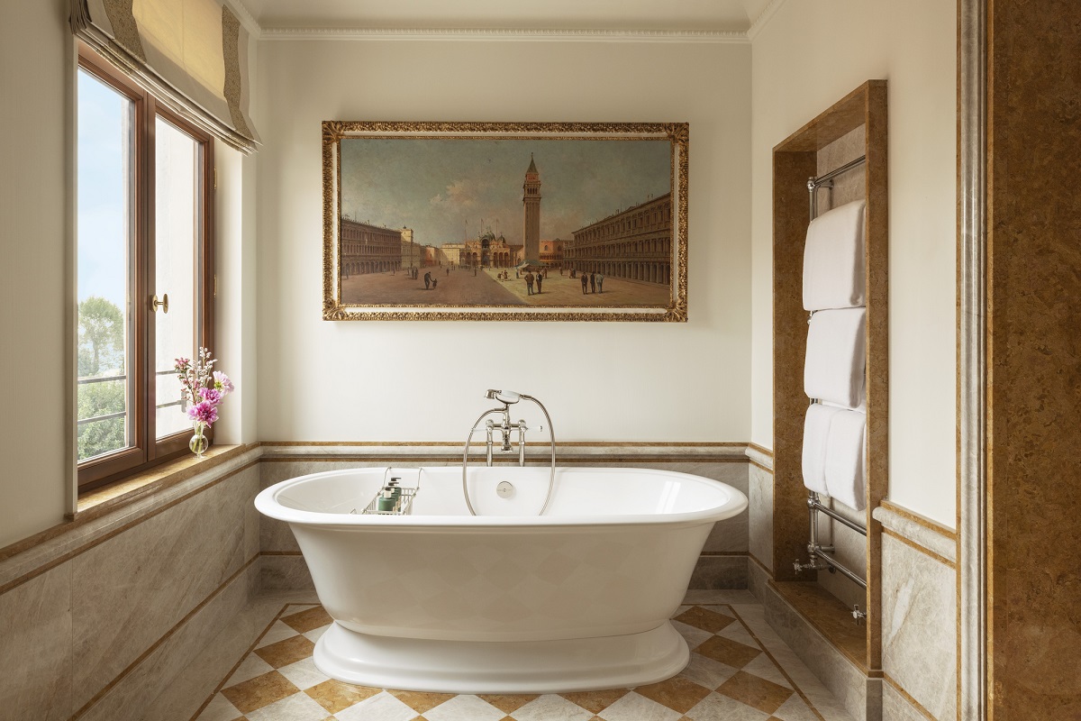 freestanding bath below antique venetian oil painting