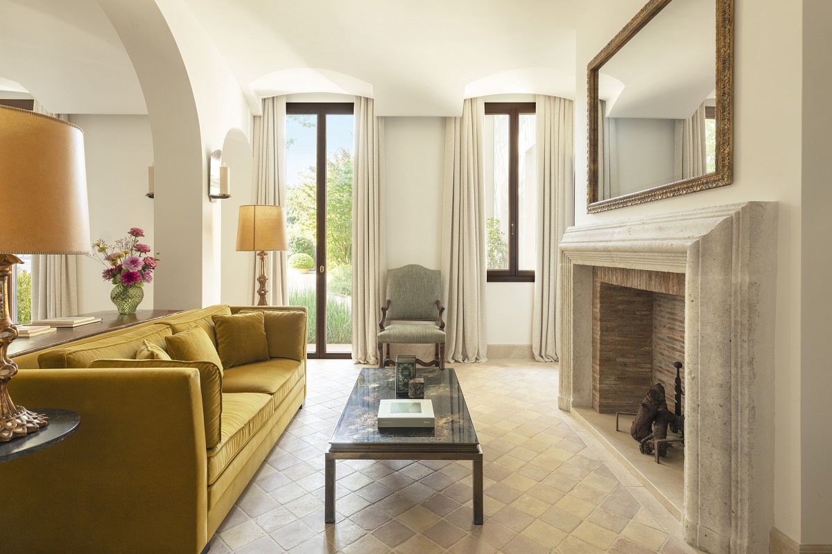 mustard yellow couch in front of fireplace in guestroom