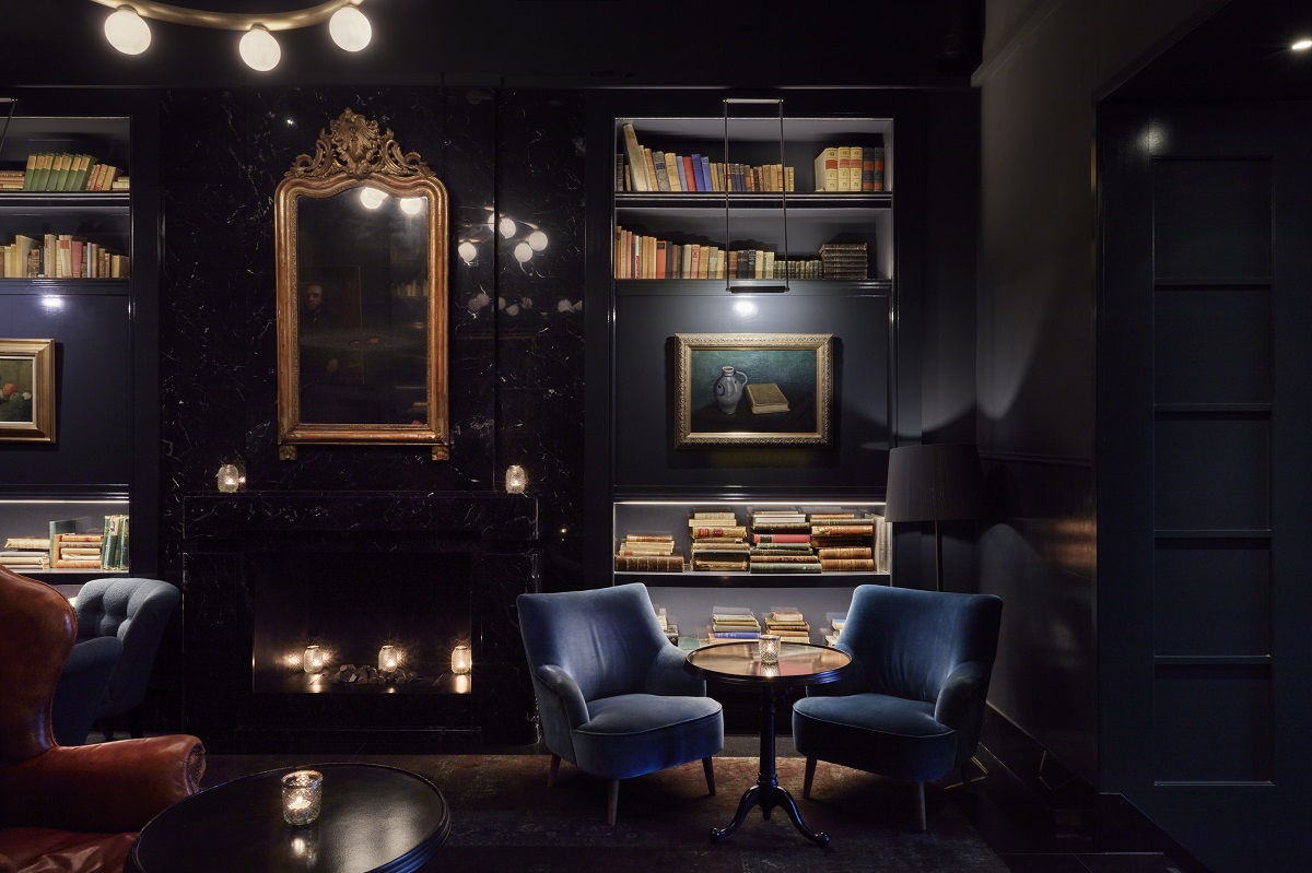 dark walls, blue velvet chairs and low lighting in the hotel bar