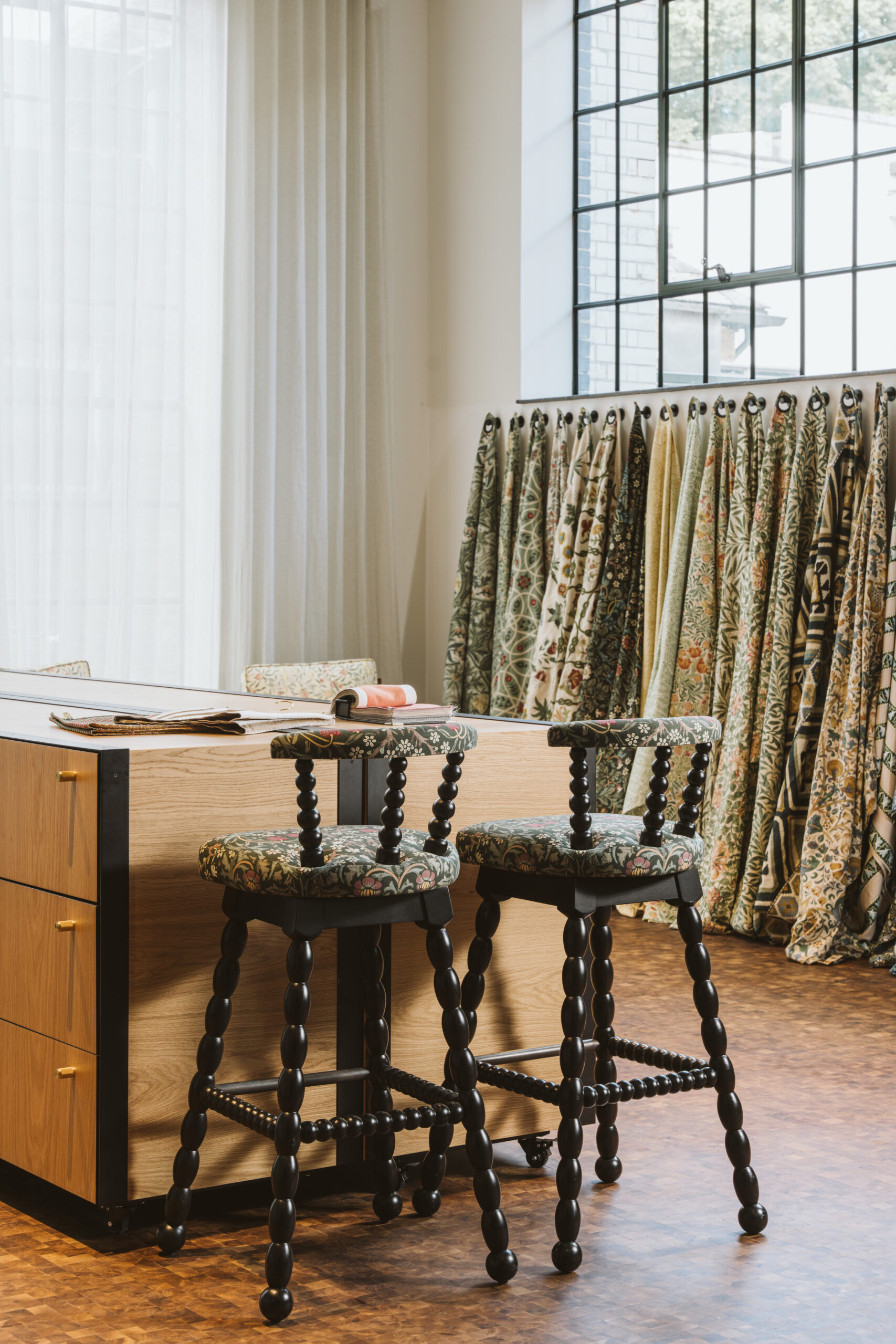 Interior of Voysey House, with Crital window above a line of fabric swatches hanging from the wall