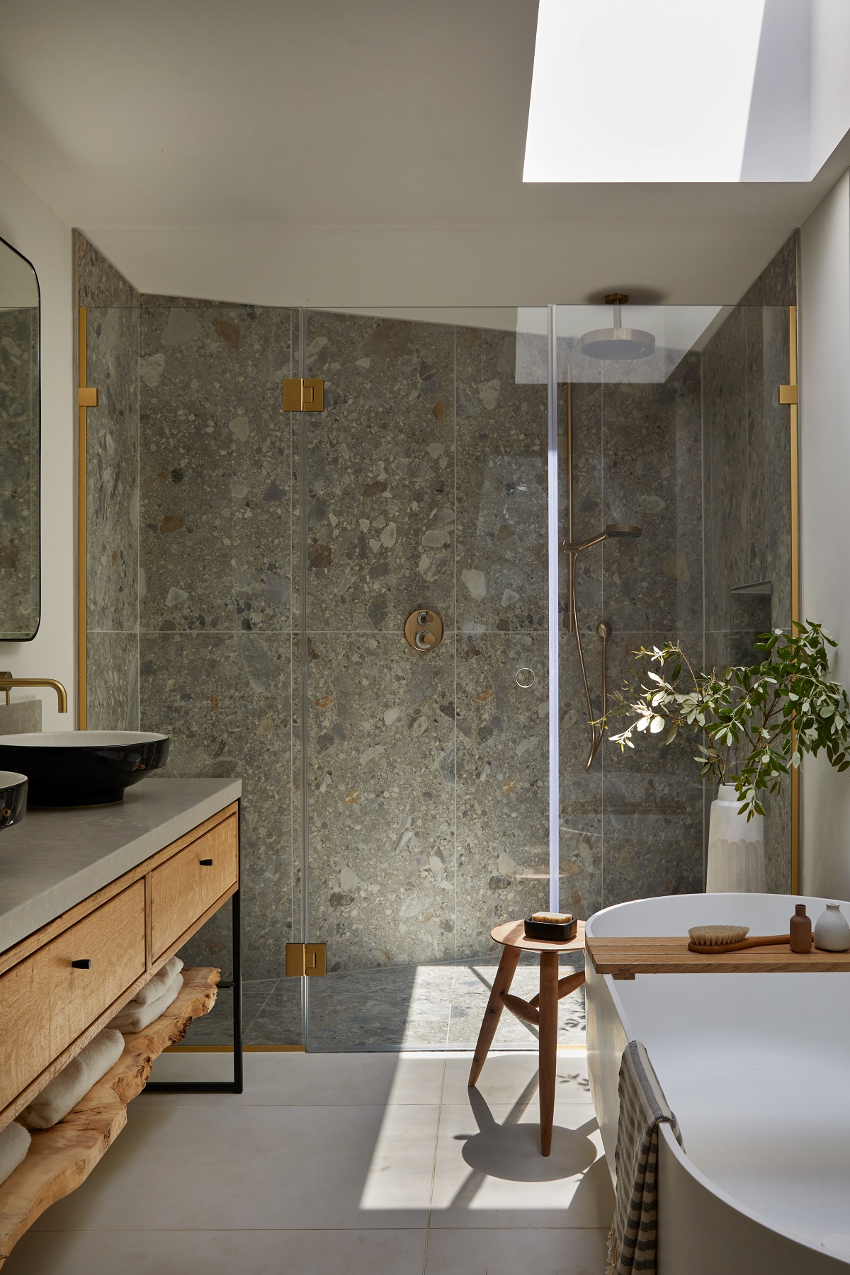 freestanding bath from House of Rohl next to wooden vanity unit