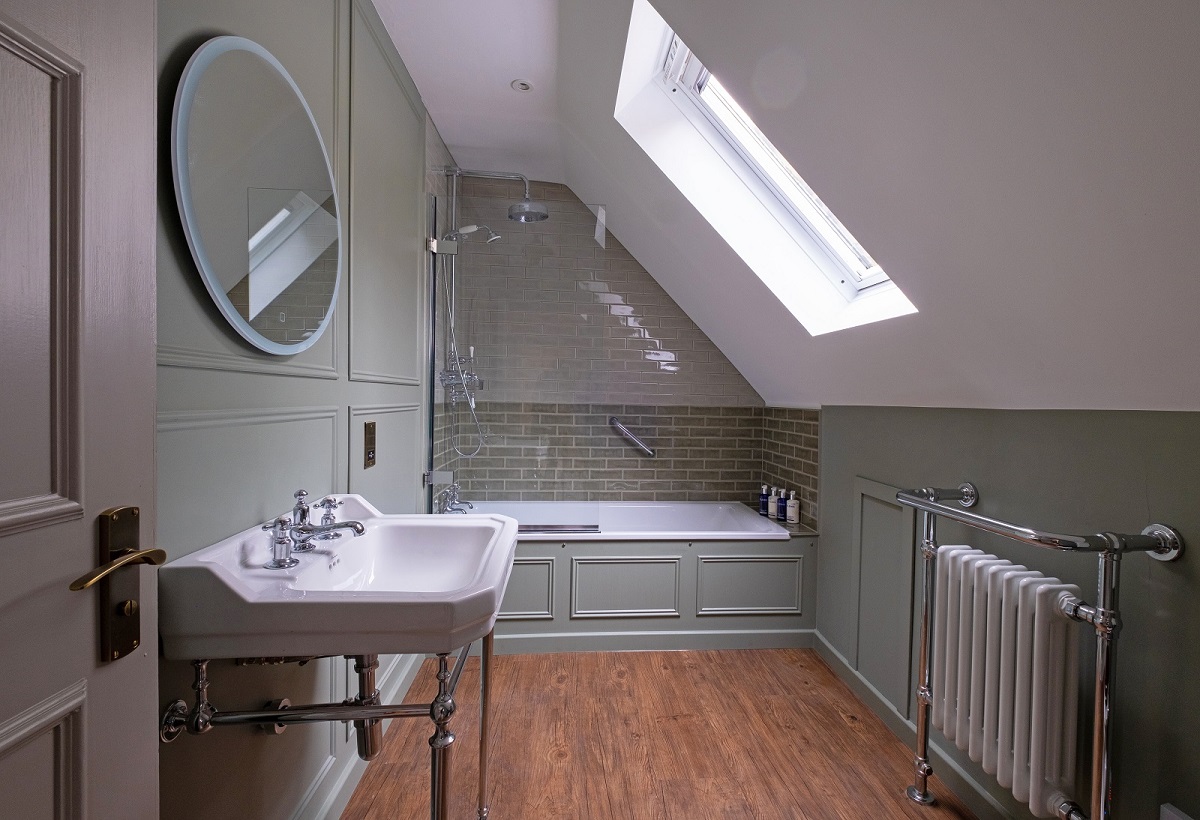 white and grey bathroom with House of Rohl bath and basin fitted into sloped ceiling alcove