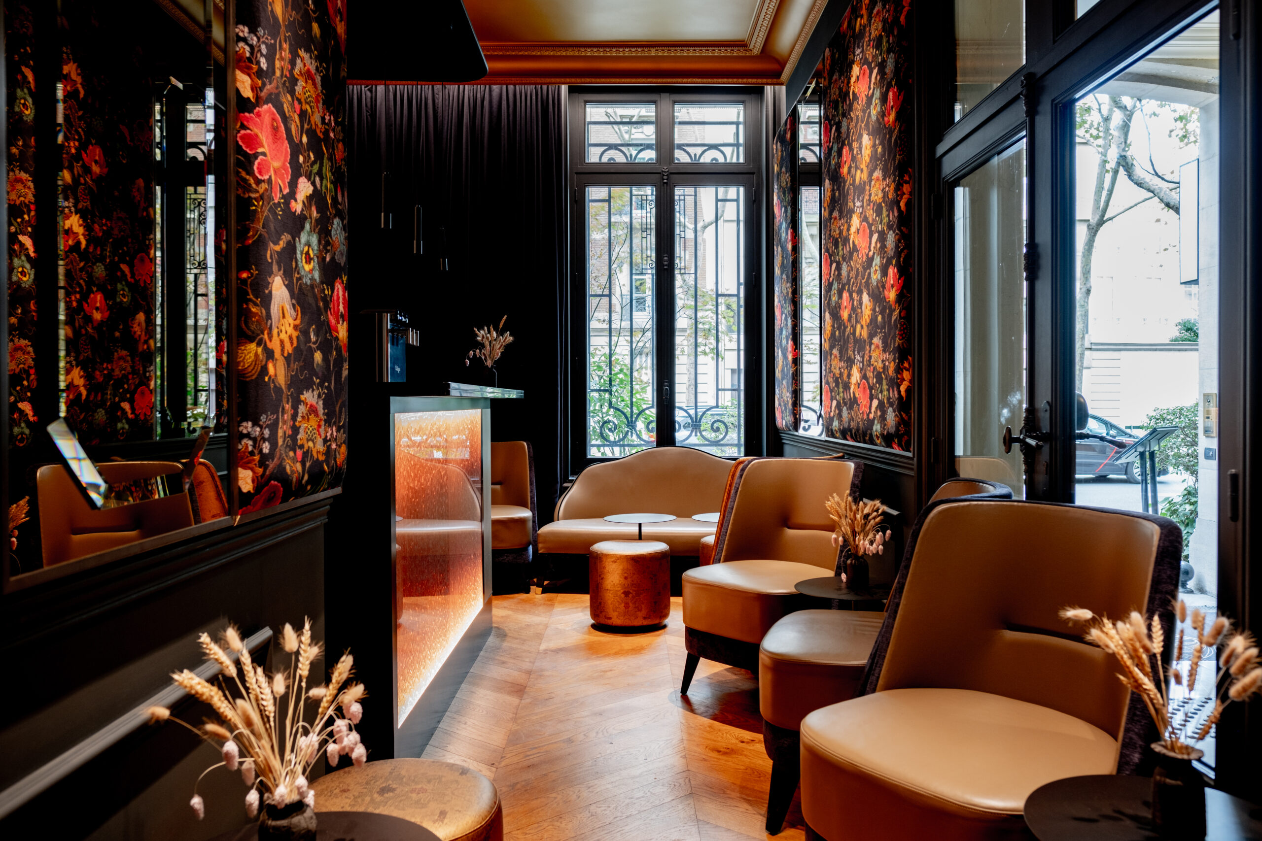 The Léopold Bar featuring richly toned floral wallpaper layered with modern textures and low lighting