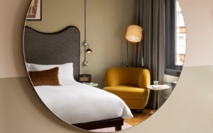 Organic circle mirror showing reflection of bed at Hoxton Shoreditch