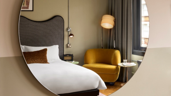 Organic circle mirror showing reflection of bed at Hoxton Shoreditch