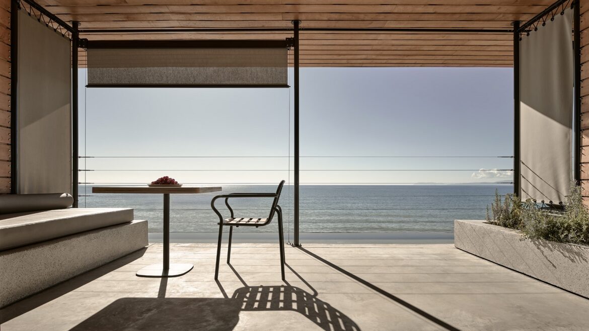 chair and table silhouetted against ocean view in Dexamenes Seaside Hotel