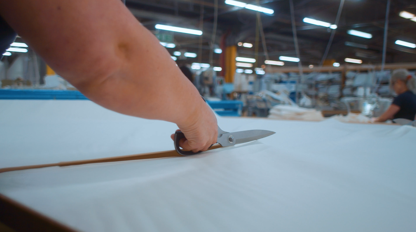 Scissors cutting through material for mattress lid