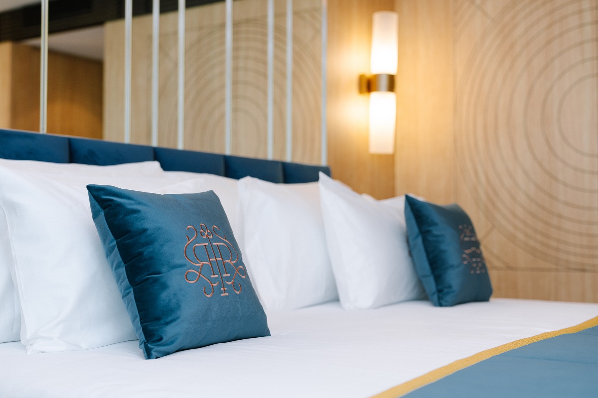 detail of bed with white linen and blue cushions in guestroom of Royal Hideaway Casablanca