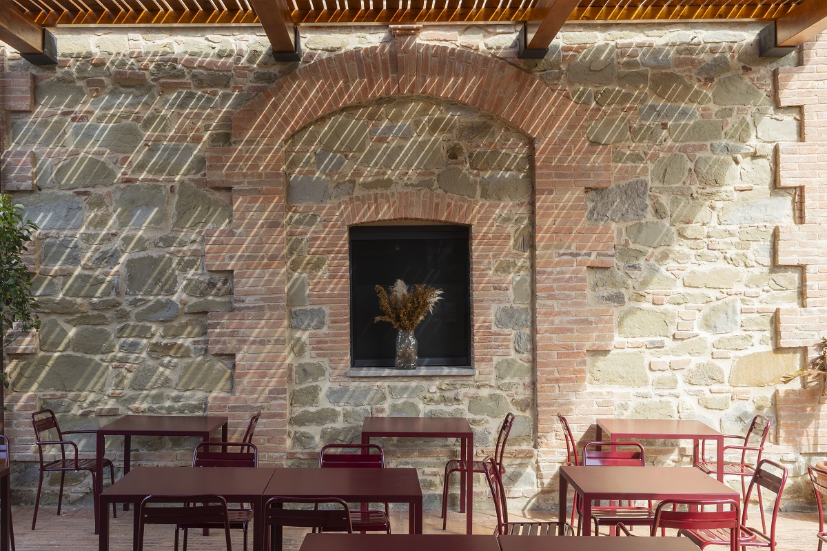 outdoor terrace with brick walls and red furniture