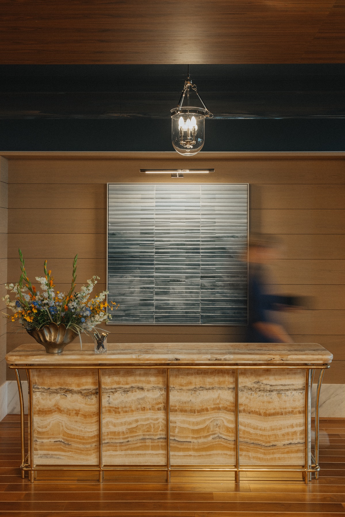 honey coloured marble reception desk in The Crossing with art behind