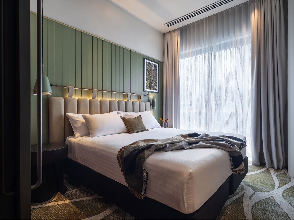 Adina Hobart guestroom with olive green panelling behind an olive green leather bedhead