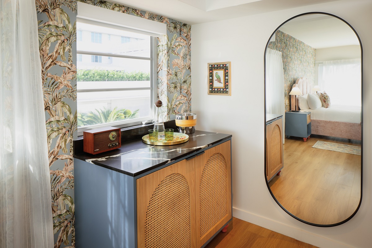 cabinet and mirror reflect bed in guestroom