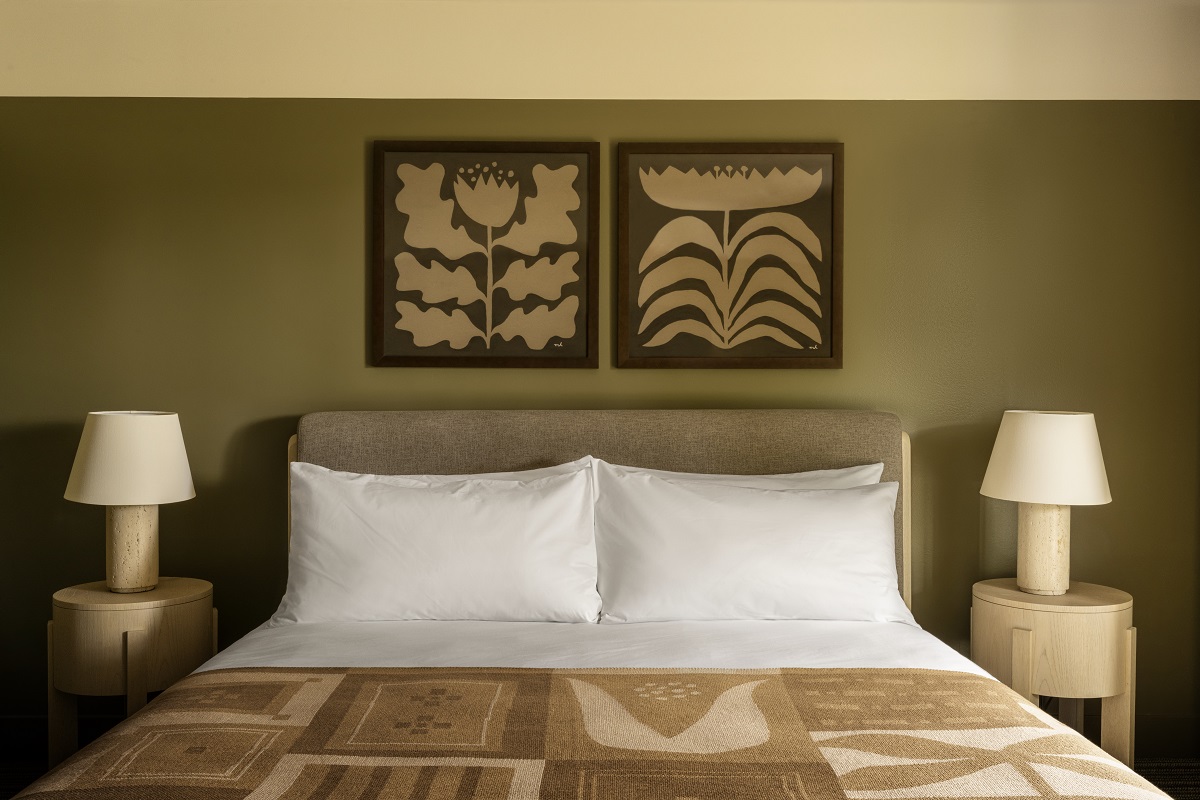 detail of bed with woven cover and bespoke art above the headboard in guestroon Hill House Mendocino