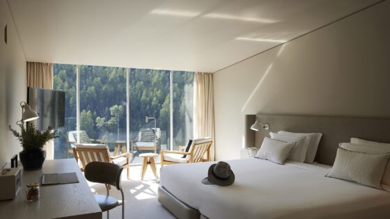 view from guestroom with floor to ceiling glass over to mountainside