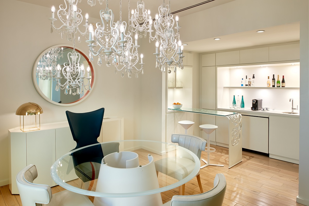 statement chandelier above glass and white table in the penthouse
