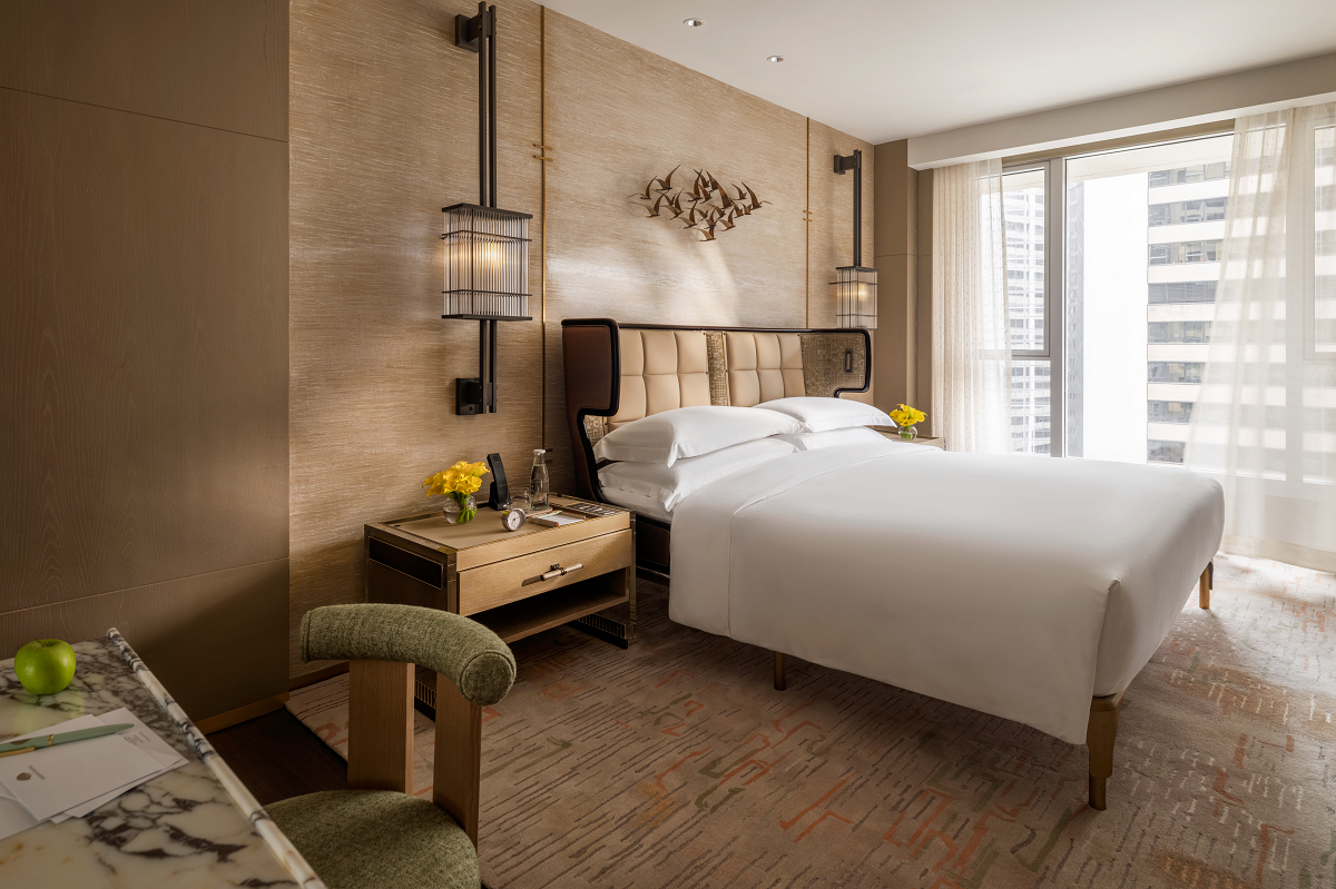 guestroom with floor to ceiling windows looking out over hong kong
