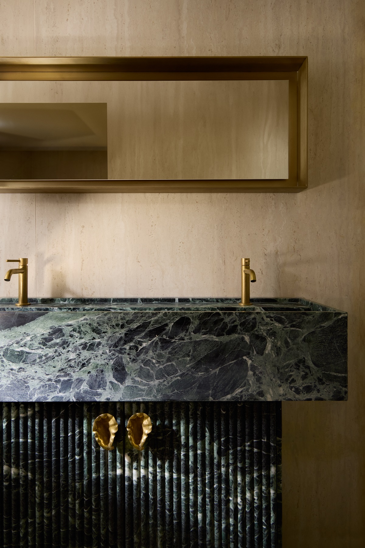 green stone vanity with handcrafted brass shell handles