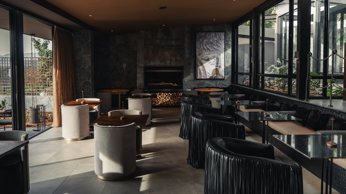 black bespoke chairs overlooking rainforest in black and brown interior