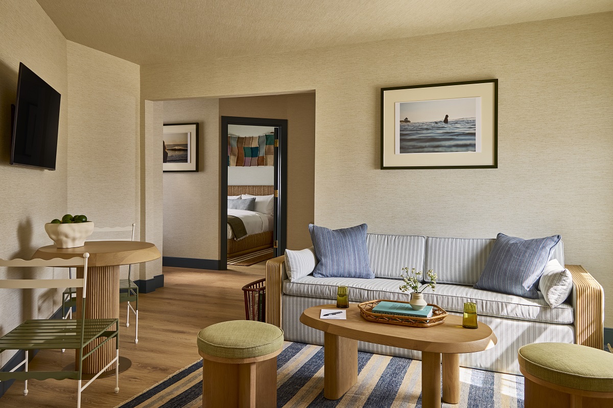 striped carpets under wooden table and sofa with cushions in Hotel Corduroy