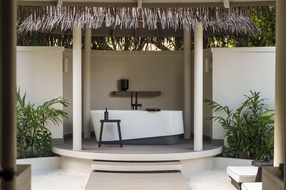 outside bath under palm thatch roof in maldives