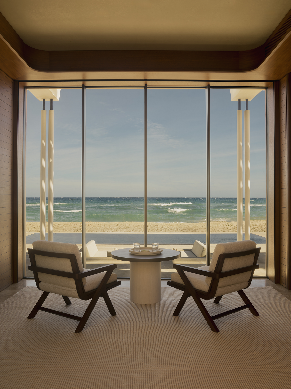 2 chairs and a table in front of floor to ceiling window with sea view at Amanvari