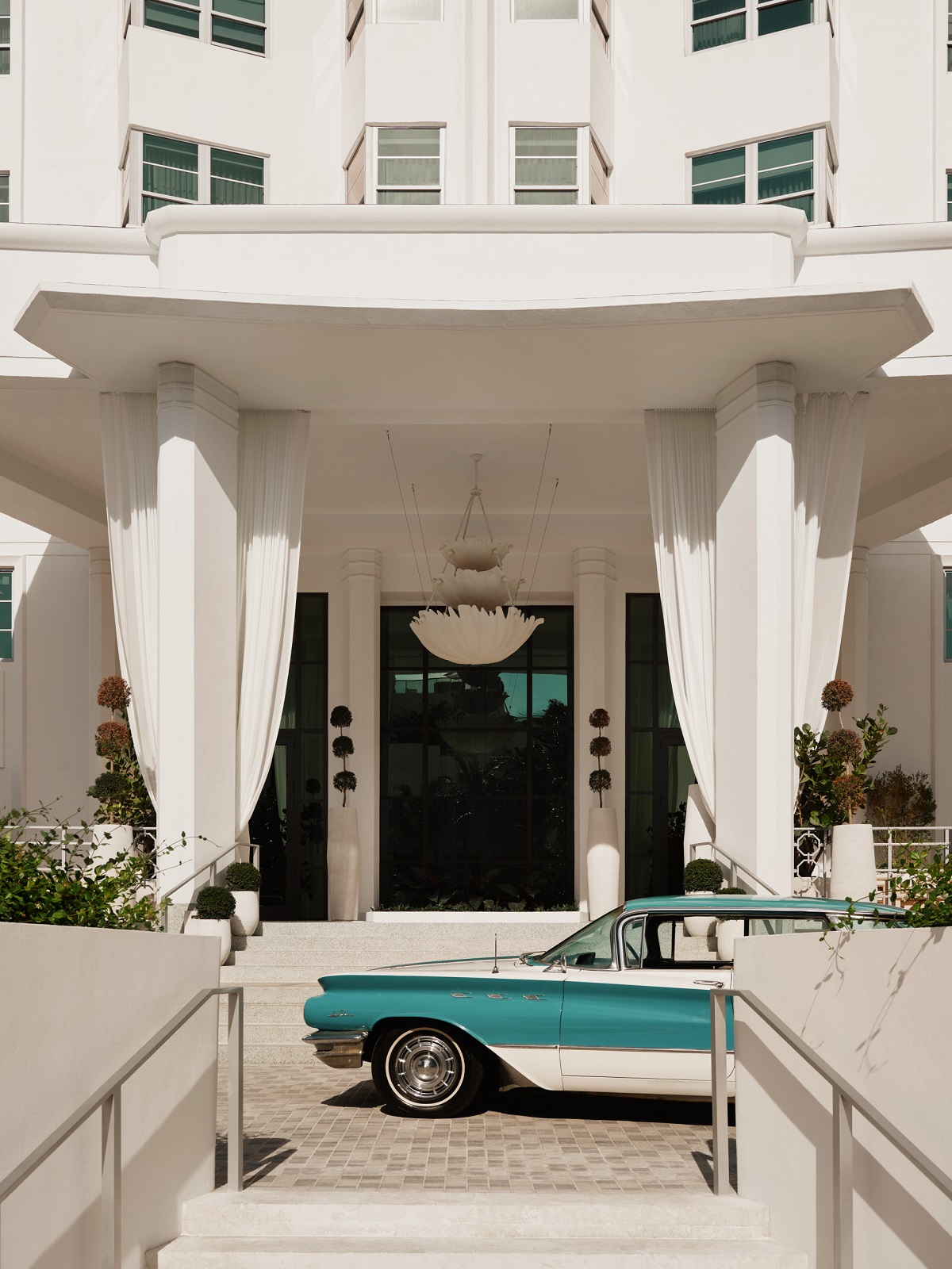 entrance to Delano miami with art deco pillars and viantage car
