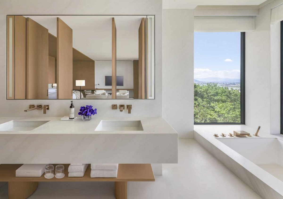white on white bathroom design with window for view from the bath
