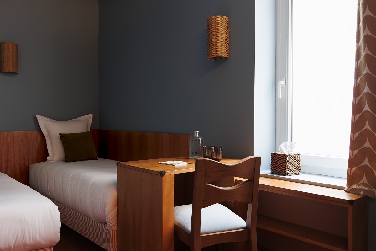 single beds in babel lille guestroom with wooden chair and desk at bed end