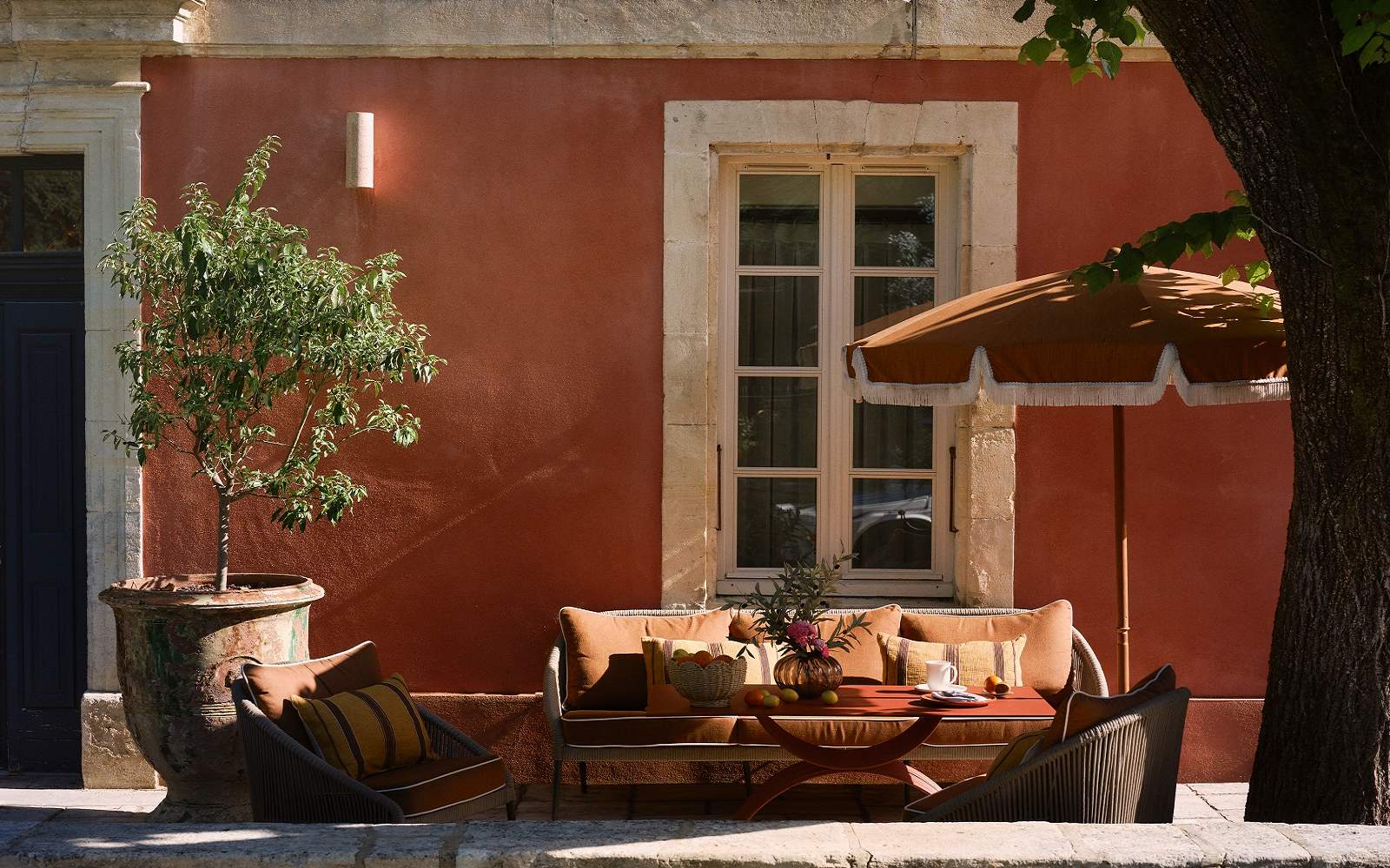 pink plaster, umbrella and couch outside villa augusta
