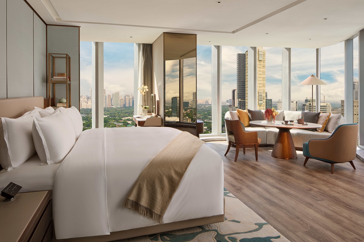 bed and seating area with views over Manila in the junior suite mandarin oriental makati