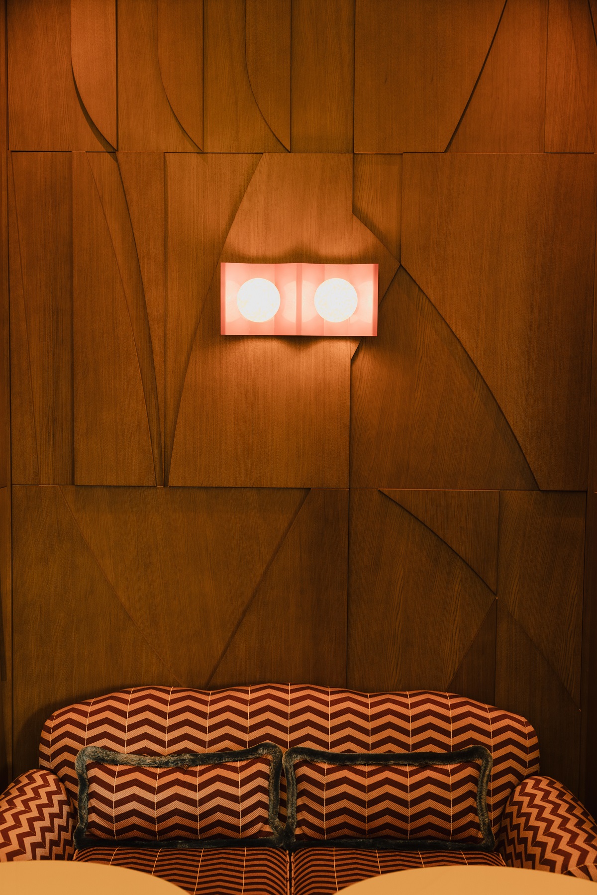 sculptural wall with bespoke lighting and striped couch
