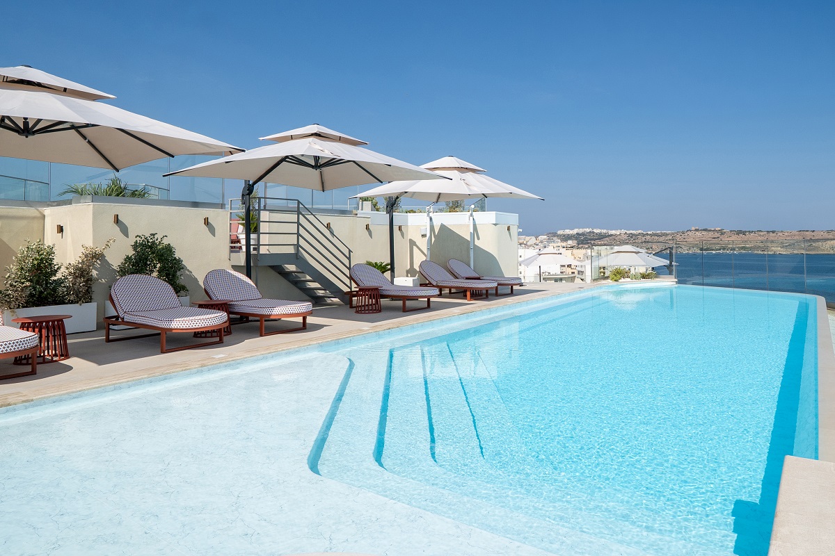 rooftop pool with white parasols and sunloungers