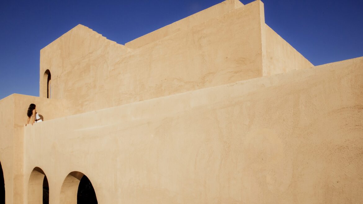 geometric clay facade against blue sky at _Nomade Temple_
