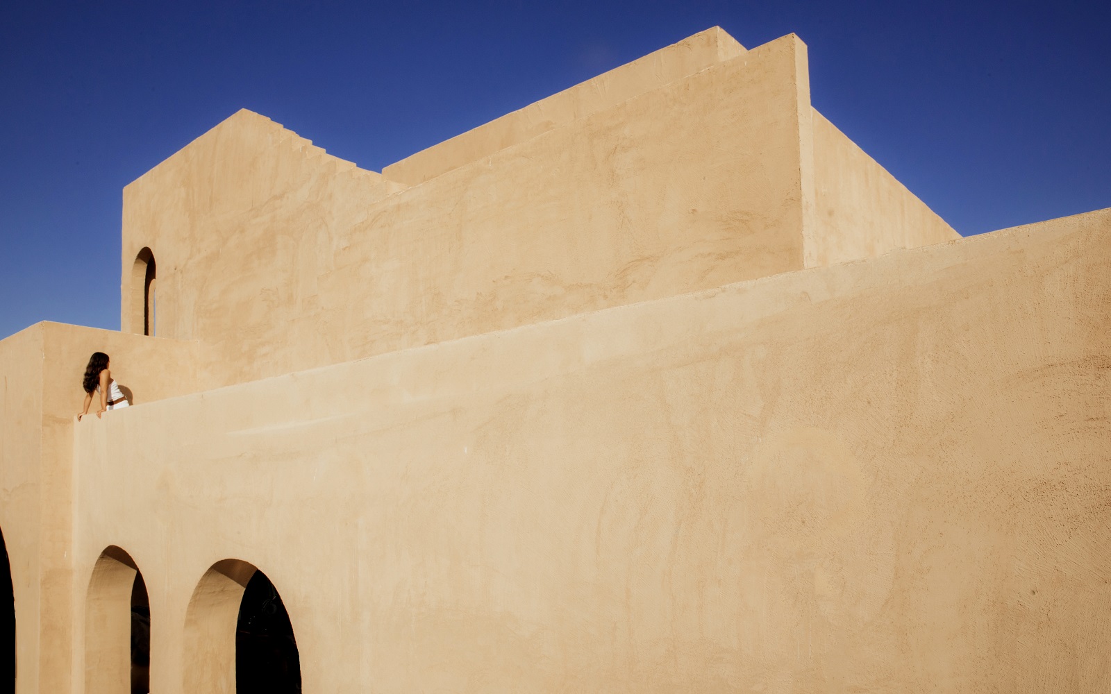 geometric clay facade against blue sky at _Nomade Temple_