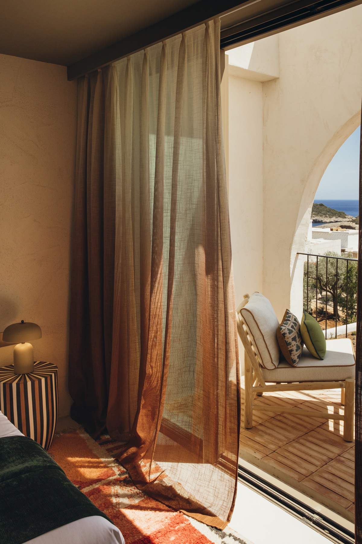 curtain in guestroom leading on to private terrace with sea view