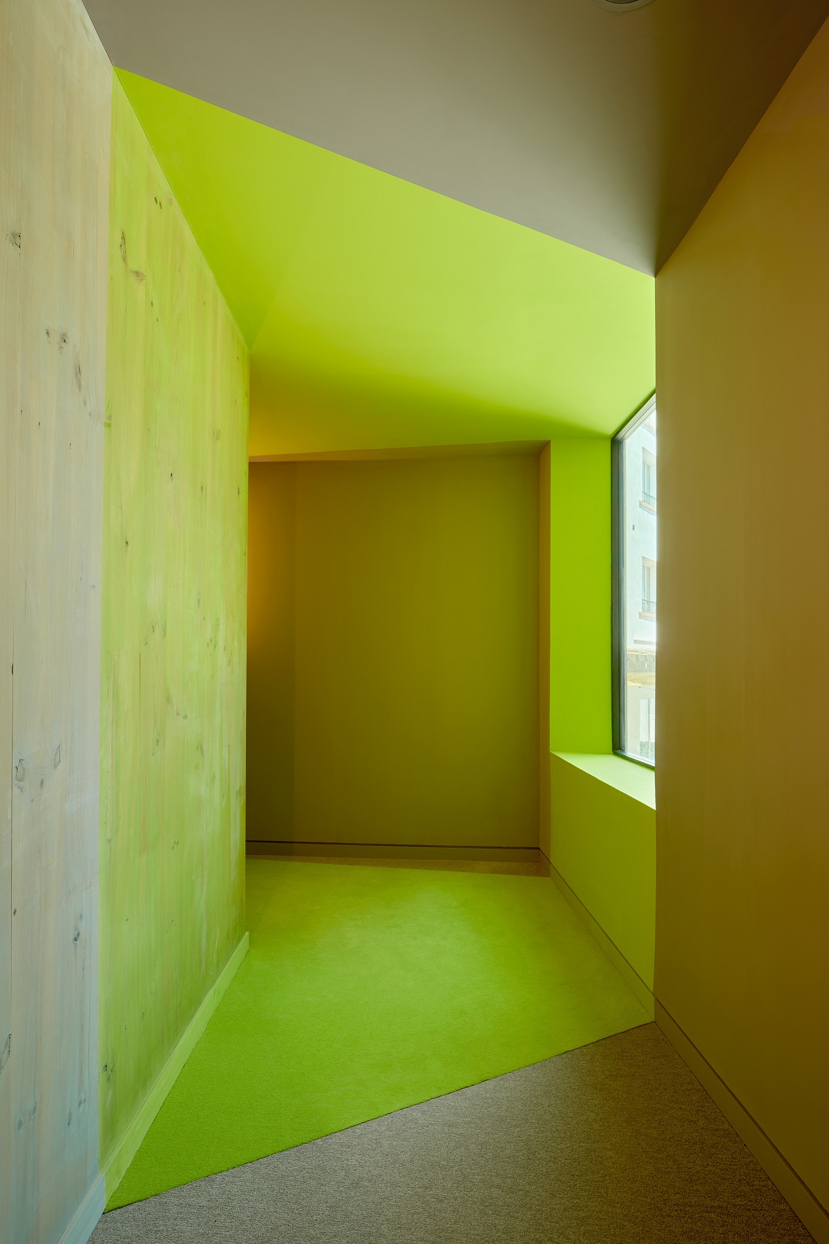 lime green corridor connecting the new wing to the old building in Terreno Barrio