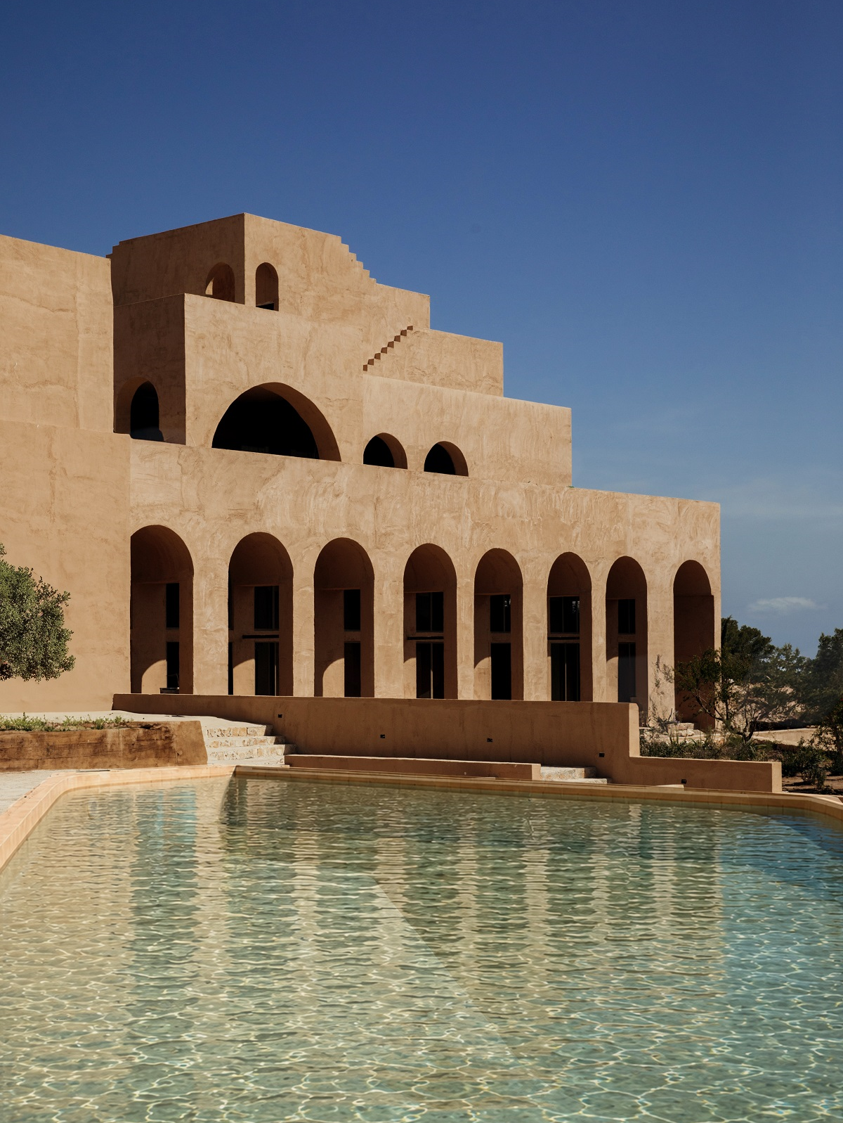 swimming pool in front of arched collonade