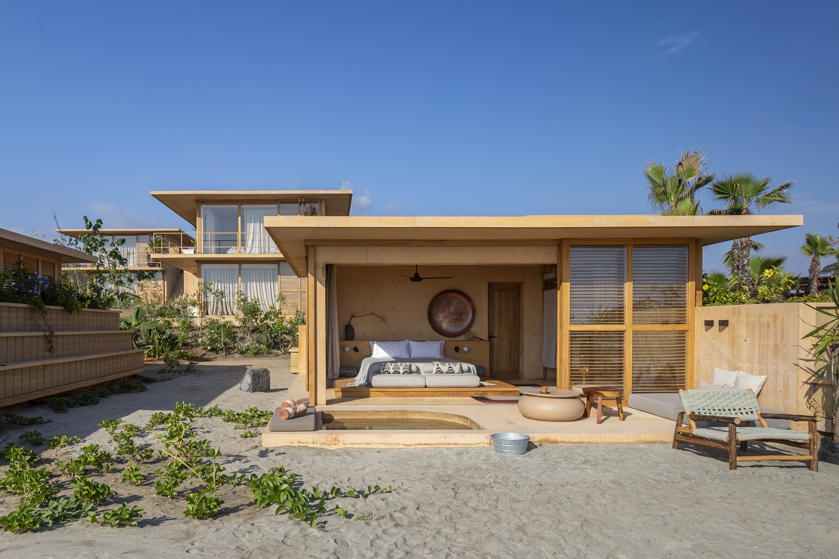 view into guestsuite bedroom with terrace and plunge pool leading onto the sand