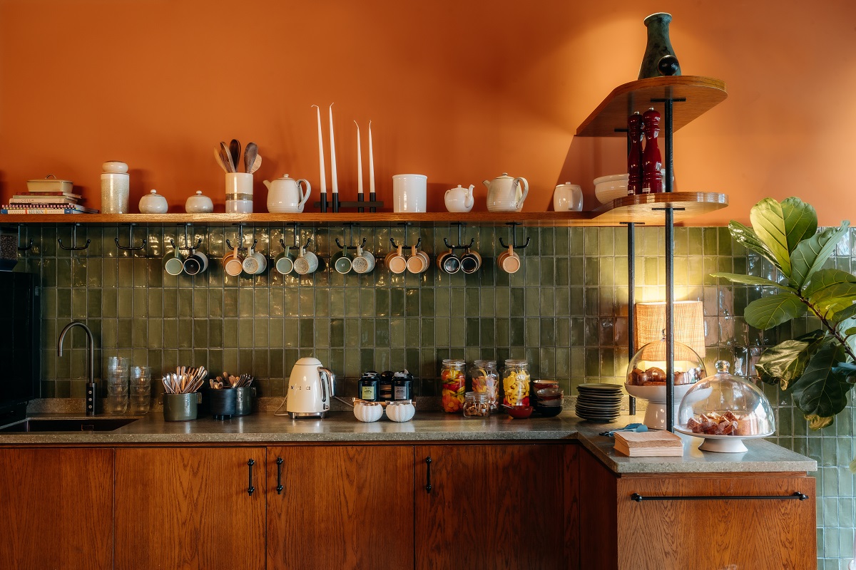 trademark bunt orange walls with green tiles above the kitchen unit in Jan Luykens reception area