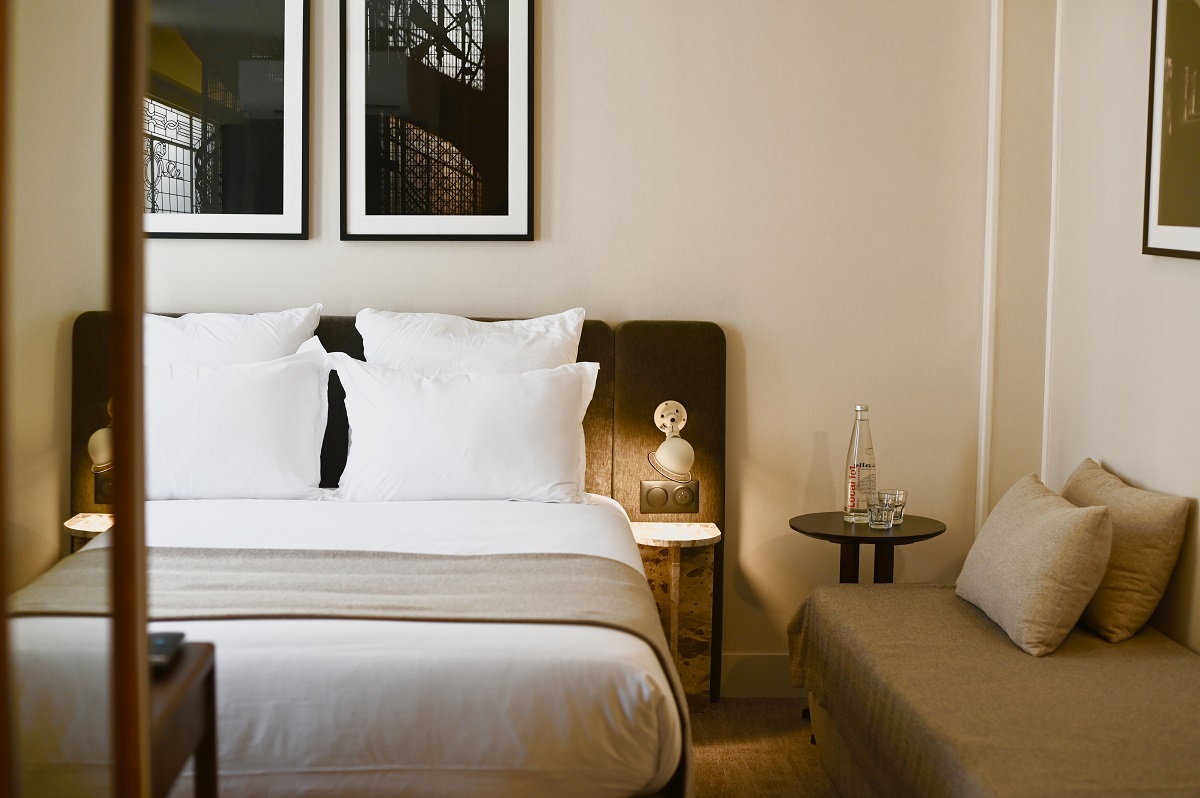 bed with white linen and throw in hotel guestroom