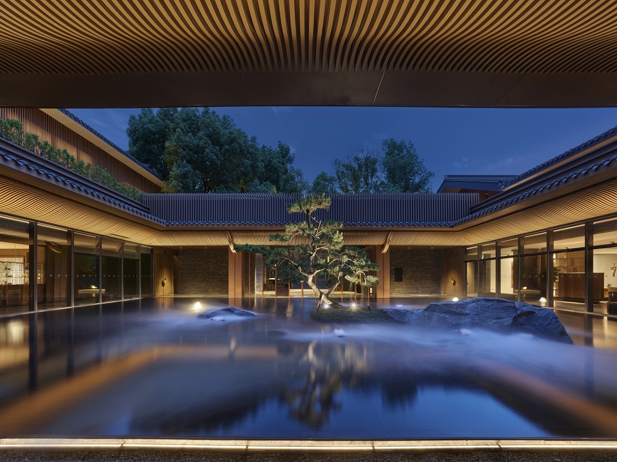 hotel atrium with water, rocks and tree