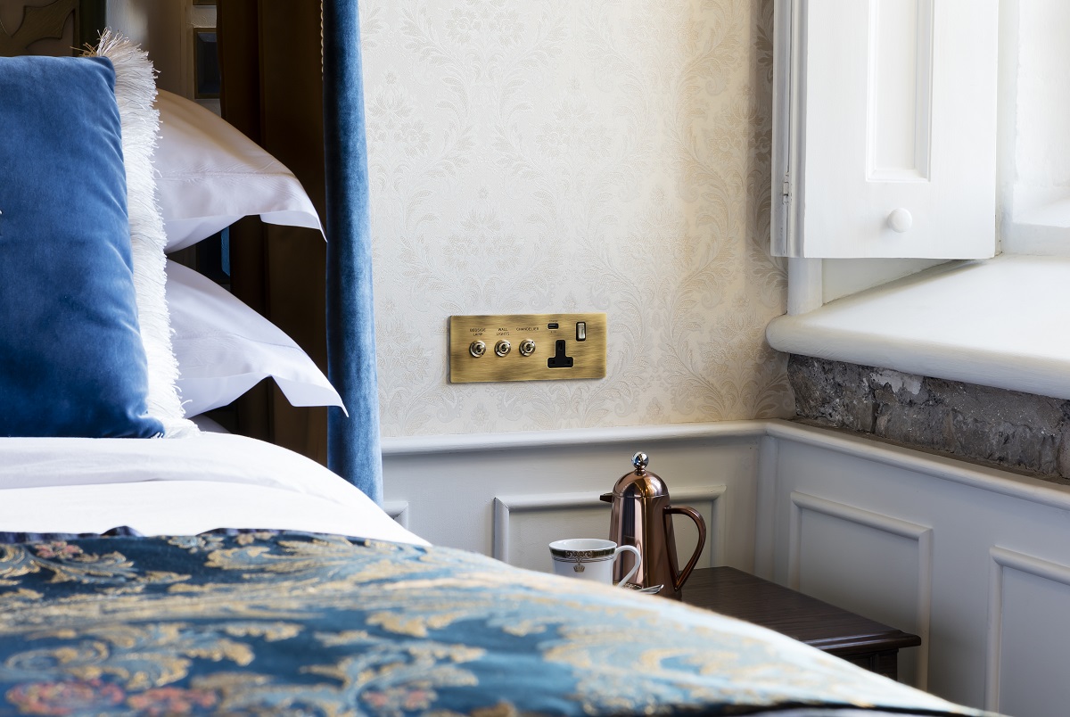 detail of bedside switches by Hamilton next to bed in hotel guestroom