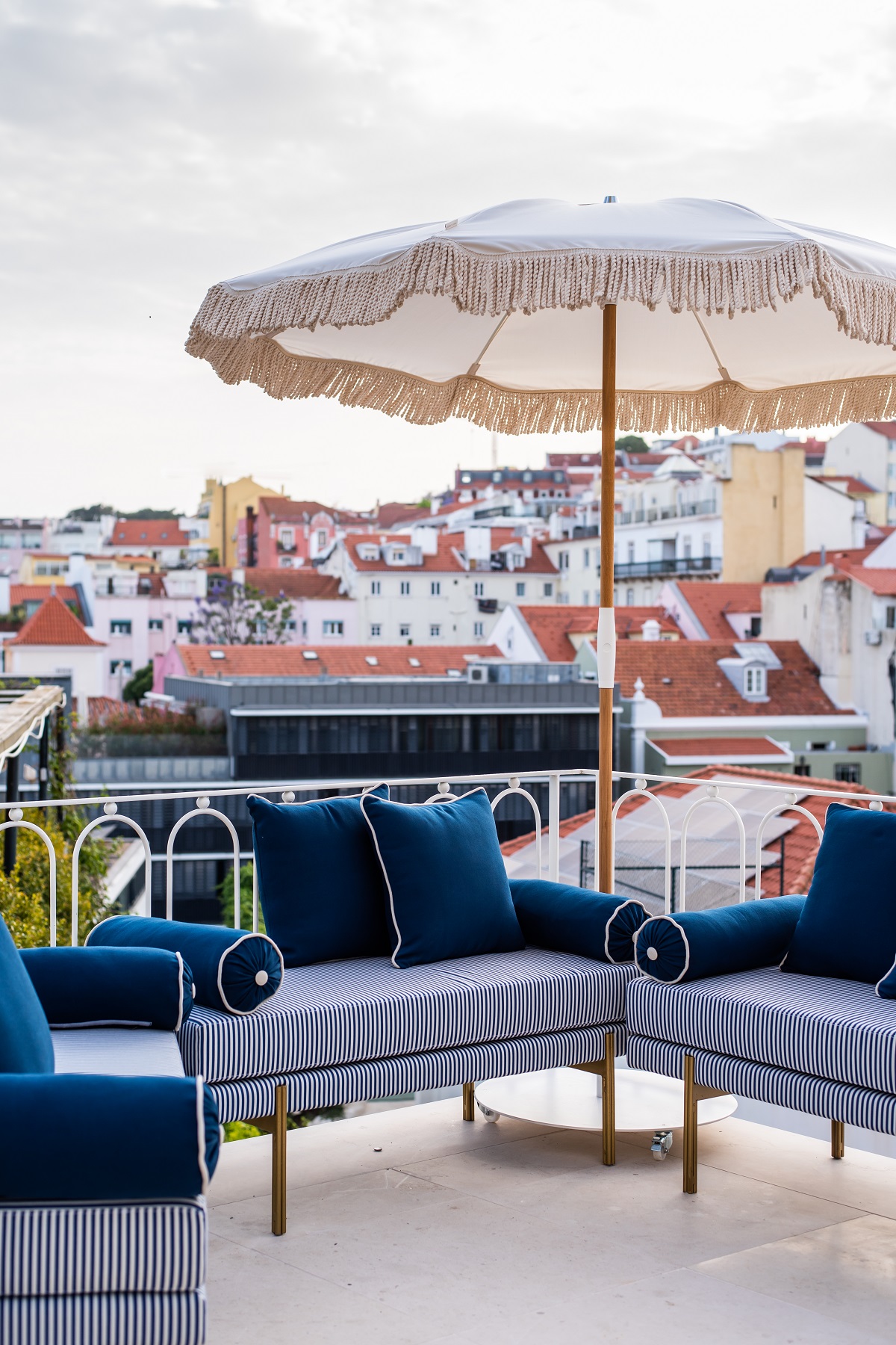blue cushions and umbrella with view of Lisbon rooftops