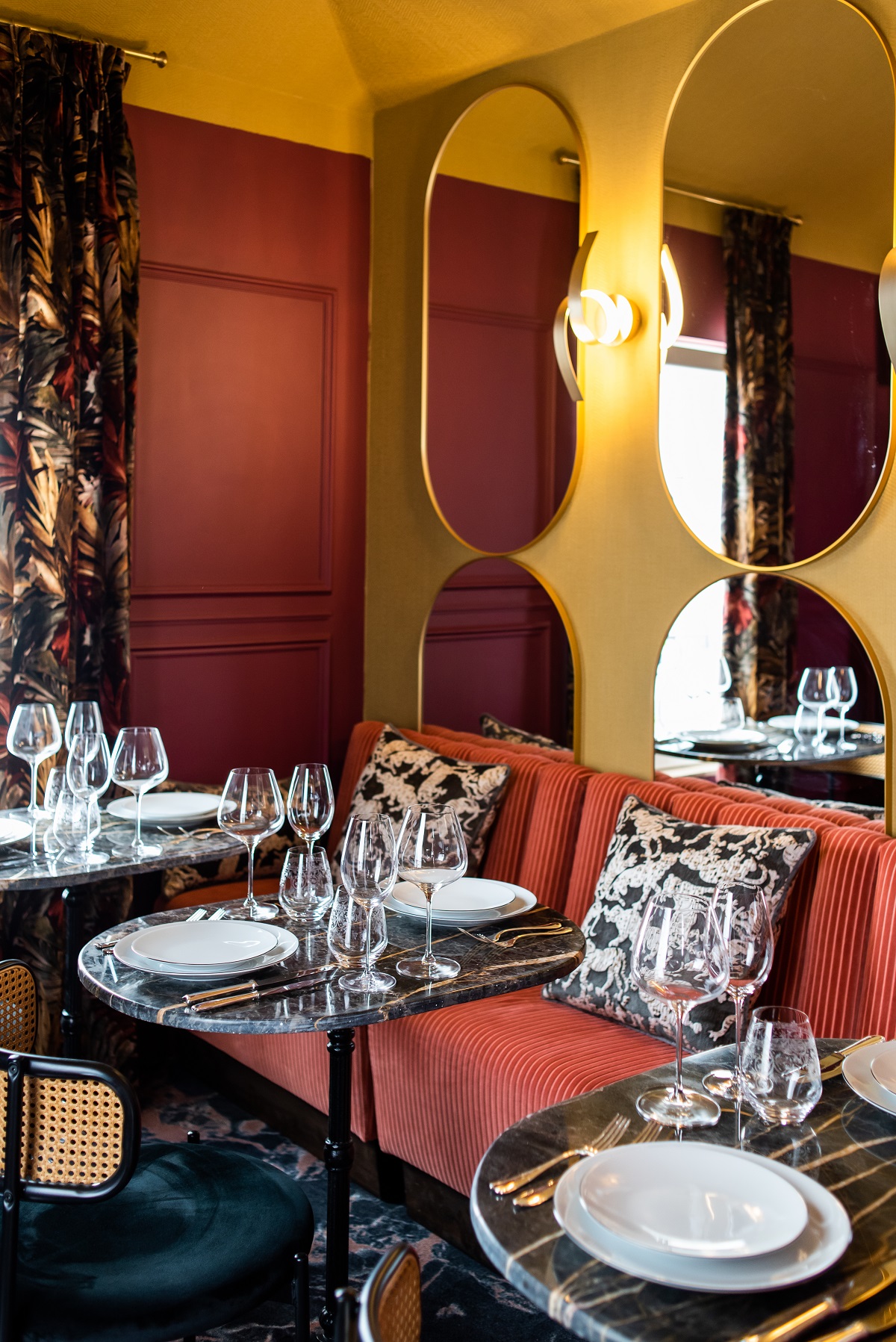 restaurant tables and banquettes with mirror behind