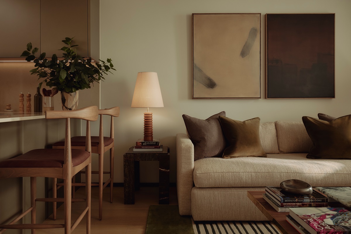 cream couch against cream wall with wood chair and beige art