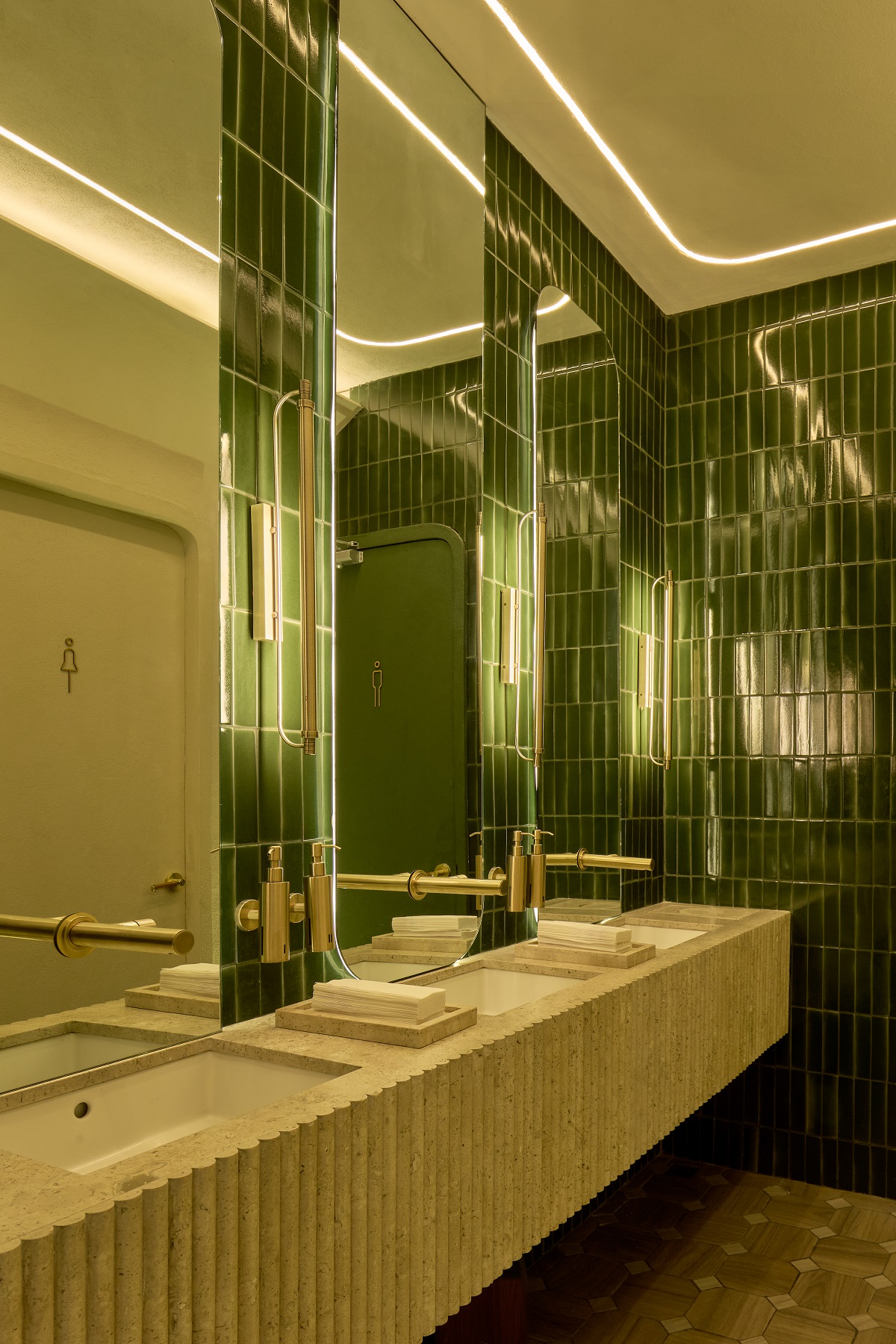 green tiles in restaurant bathroom refelct tropical plants in the design