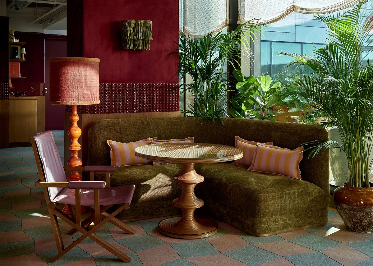 green banquette, red wall and plants in Wilde Amsterdam lobby