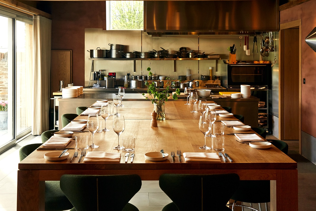 long dining table in front of open kitchen at Fowlescombe Farm